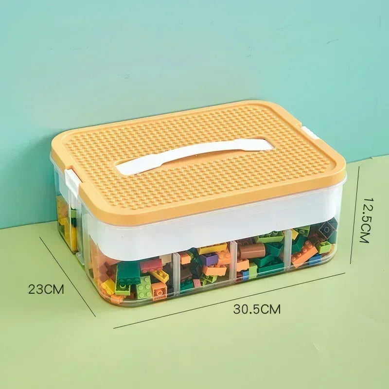 Single-layer Lego-compatible storage box with orange lid and labeled dimensions 30.5 x 23 x 12.5 cm, filled with colorful building blocks